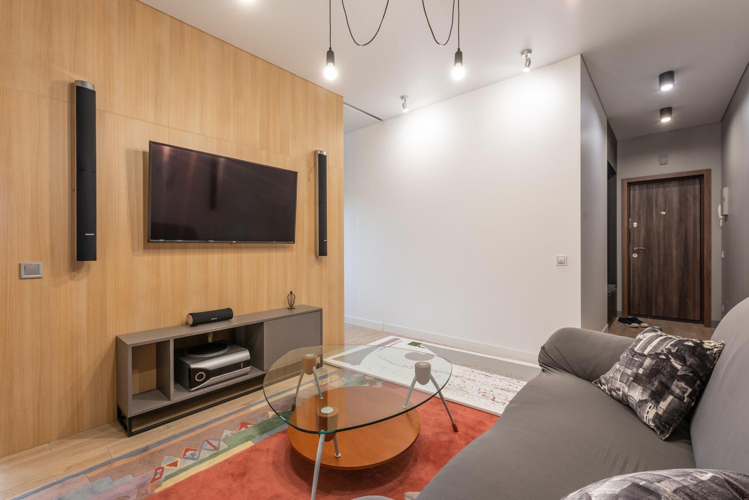 Salón contemporáneo con Smart TV y sistema de altavoces, representando la optimización del sonido y el uso de barras de sonido.