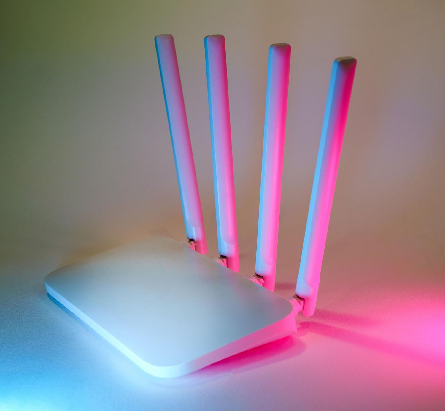 Router inalámbrico de alto rendimiento con luces neón que representa una conexión Wi-Fi rápida y estable.