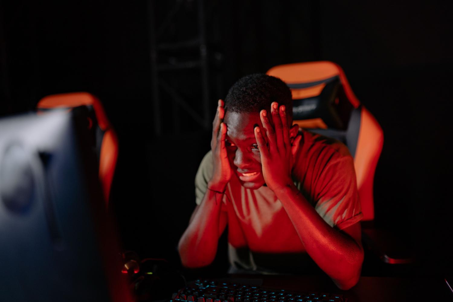 Gamer frustrado reaccionando ante el lag o la pérdida de conexión en su setup de PC.