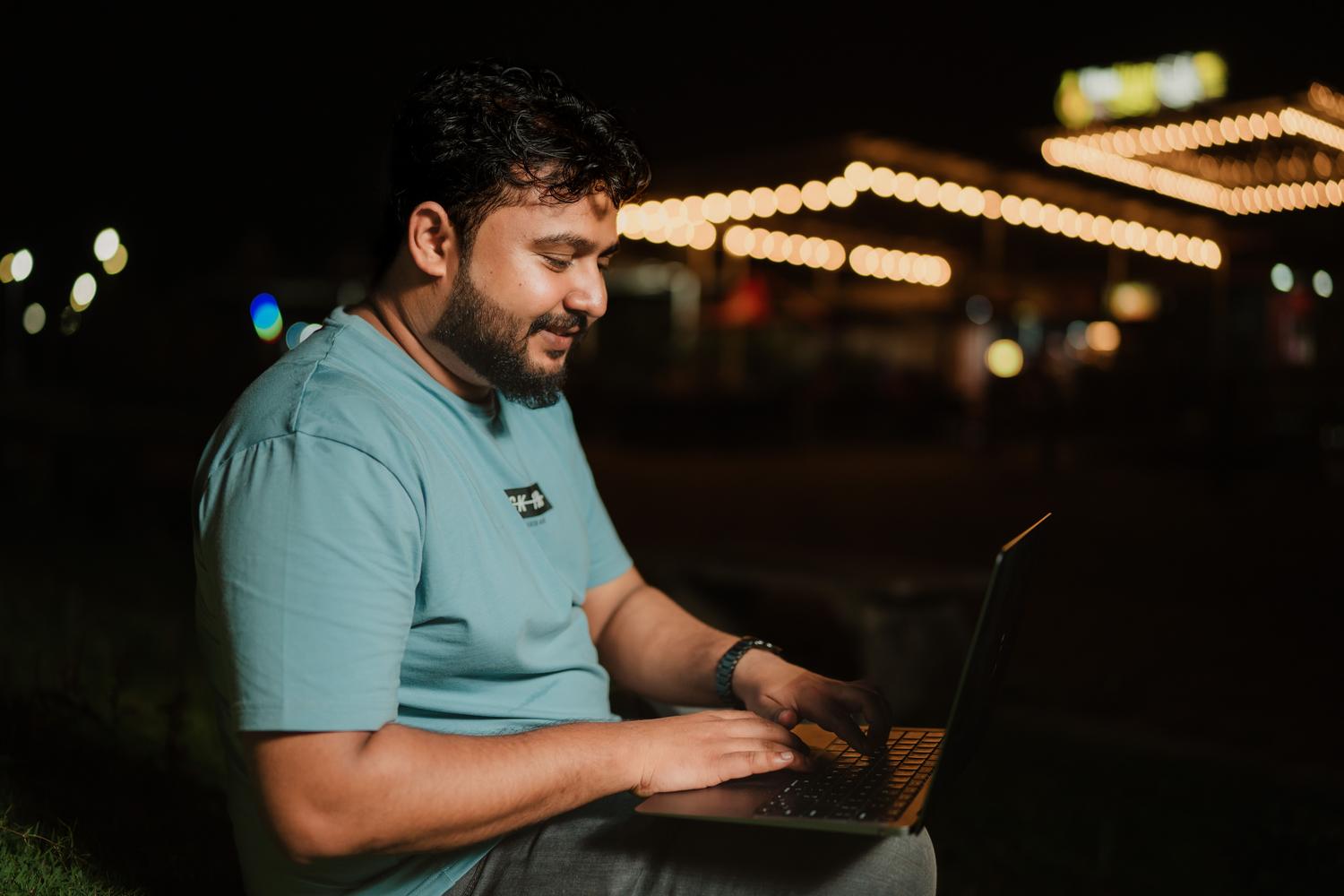 Hombre sonriendo mientras usa su portátil tras solucionar el problema de conexión Wi-Fi.