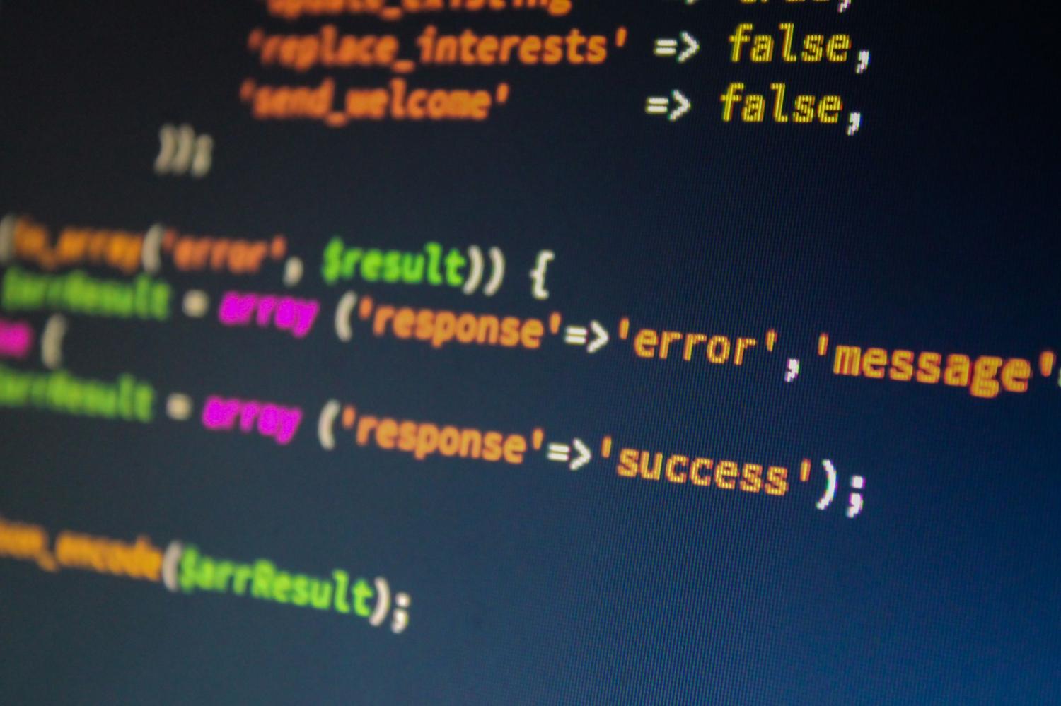 Monitor con código de programación y errores técnicos, representando la reparación de la caché de iconos y el registro
