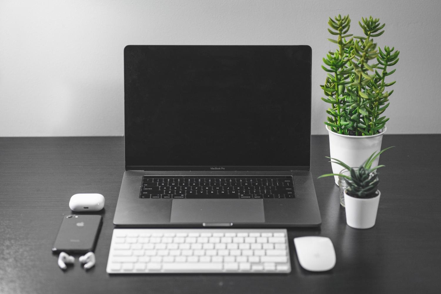 Escritorio limpio y organizado con un MacBook y plantas, evocando el minimalismo de Things 3.