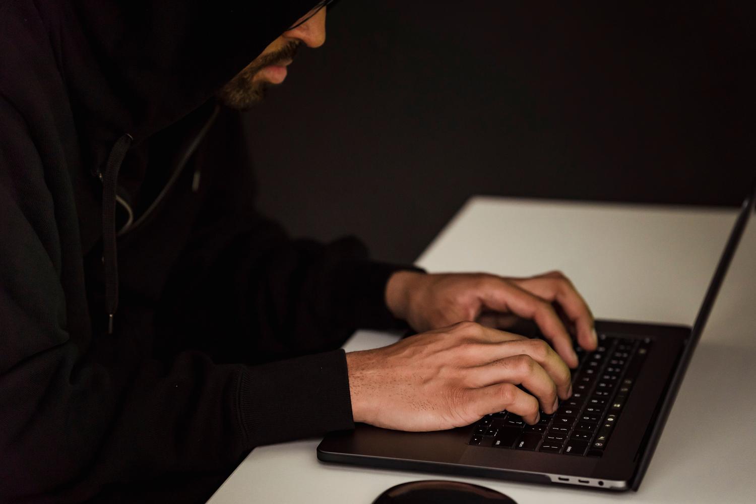 Imagen conceptual de un ciberdelincuente trabajando en la sombra, representando las amenazas y la superficie de ataque en redes corporativas.