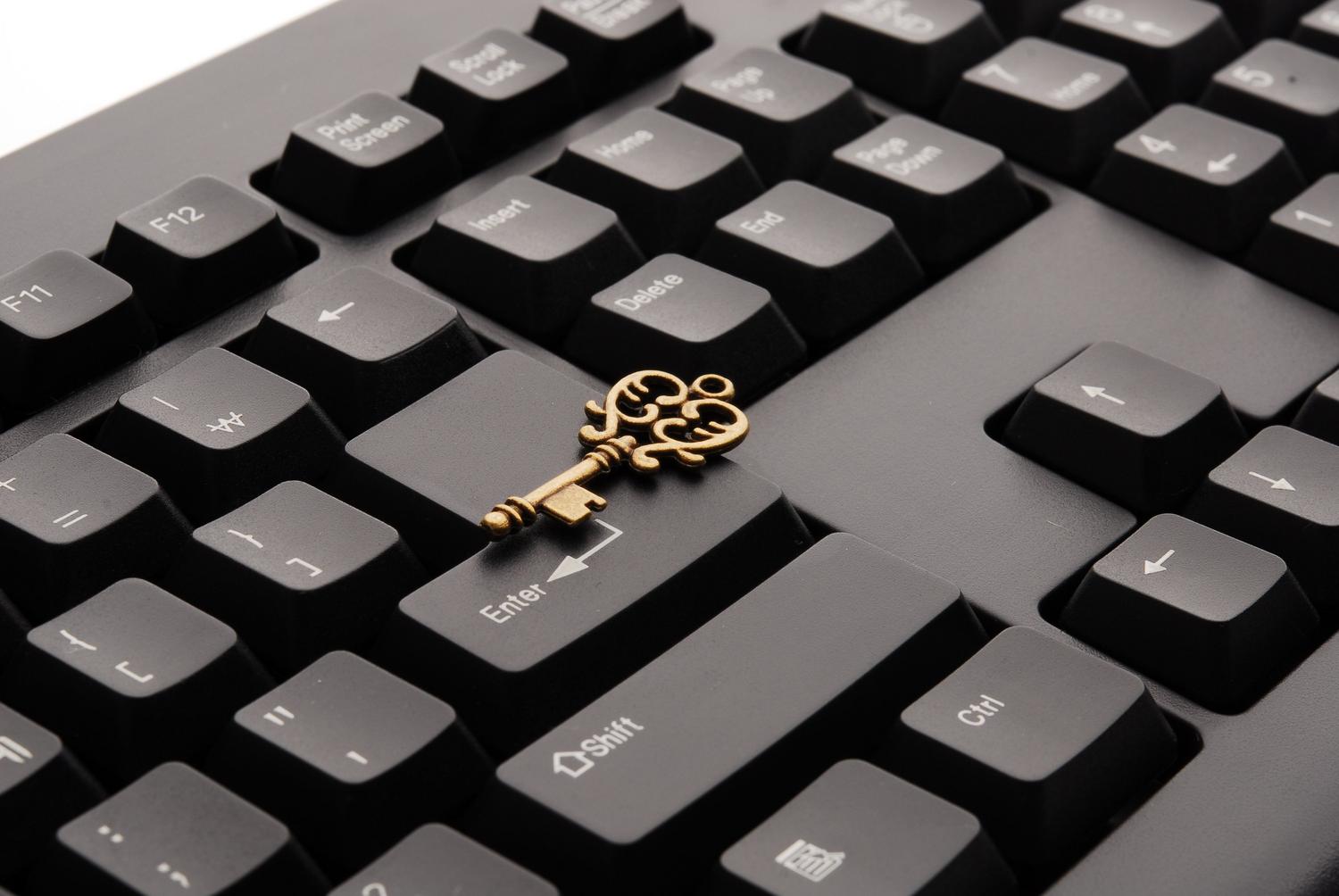 Llave antigua sobre un teclado de ordenador moderno, simbolizando el poder y acceso total de una cuenta de administrador.