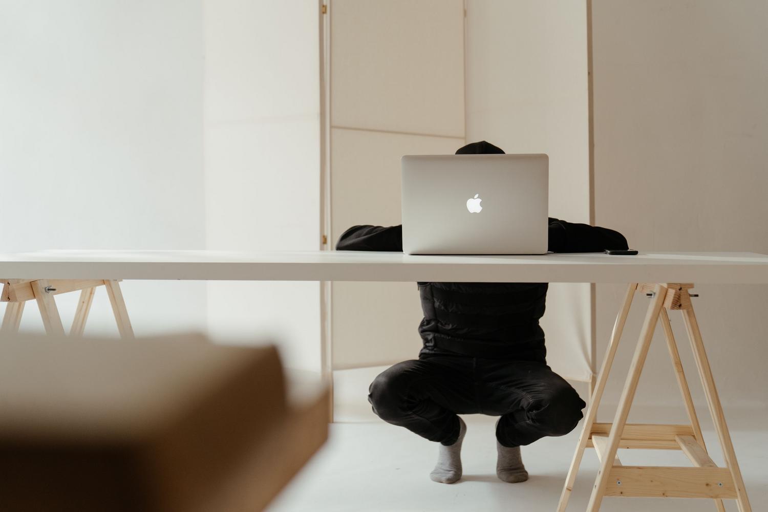 Imagen minimalista de un MacBook sobre una mesa blanca, representando el entorno de macOS.