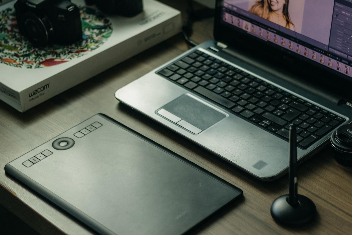 Configuración de artista digital con portátil y tableta gráfica sobre un escritorio