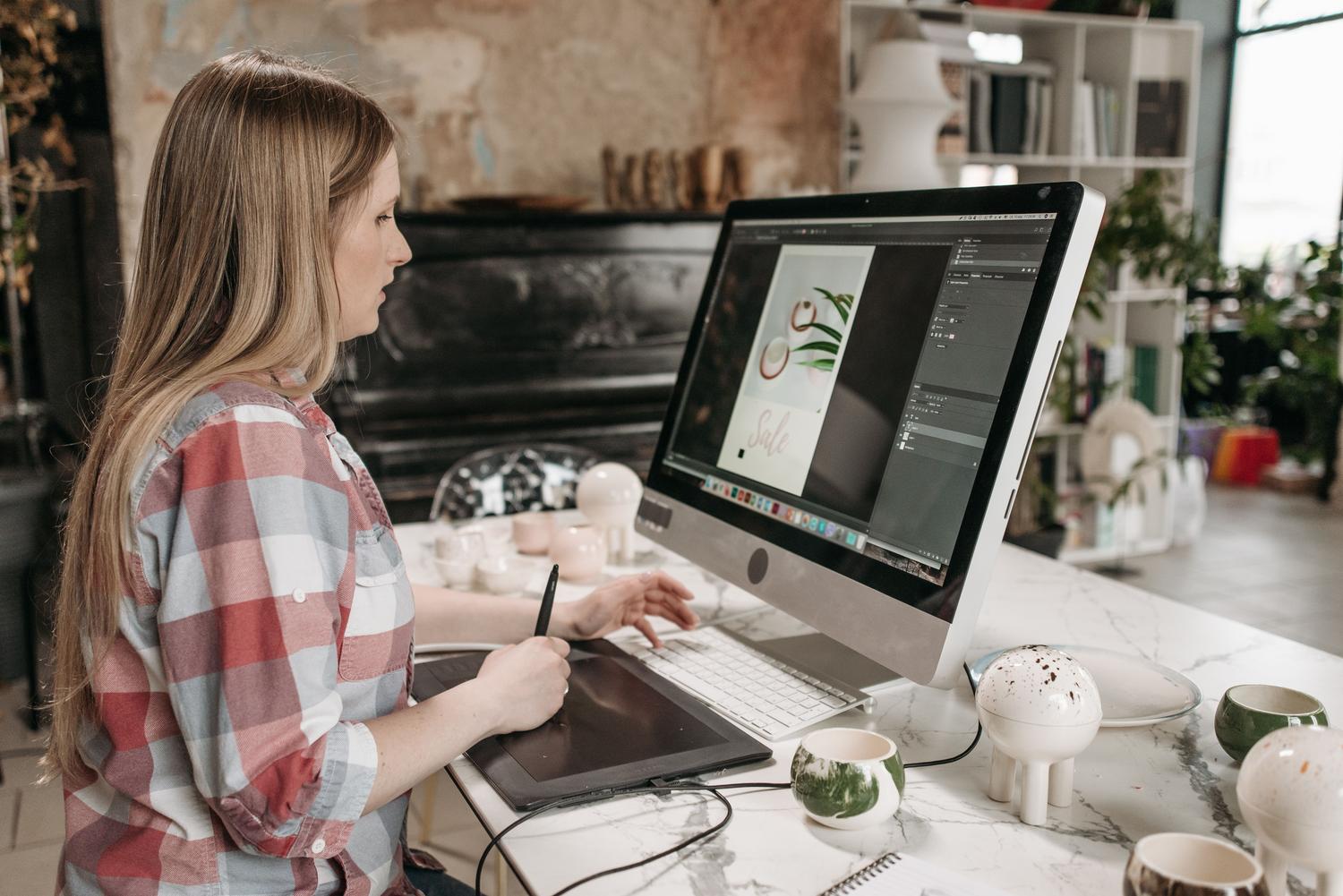 Diseñadora gráfica trabajando concentrada con una tableta digital en una oficina moderna