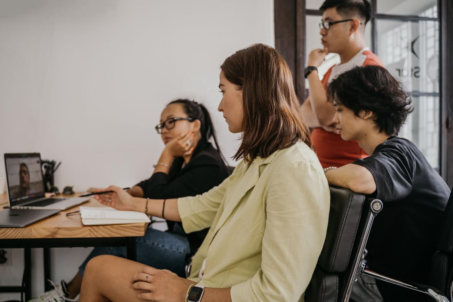 Grupo de profesionales en una reunión colaborativa mediante videollamada en un entorno de oficina moderno.