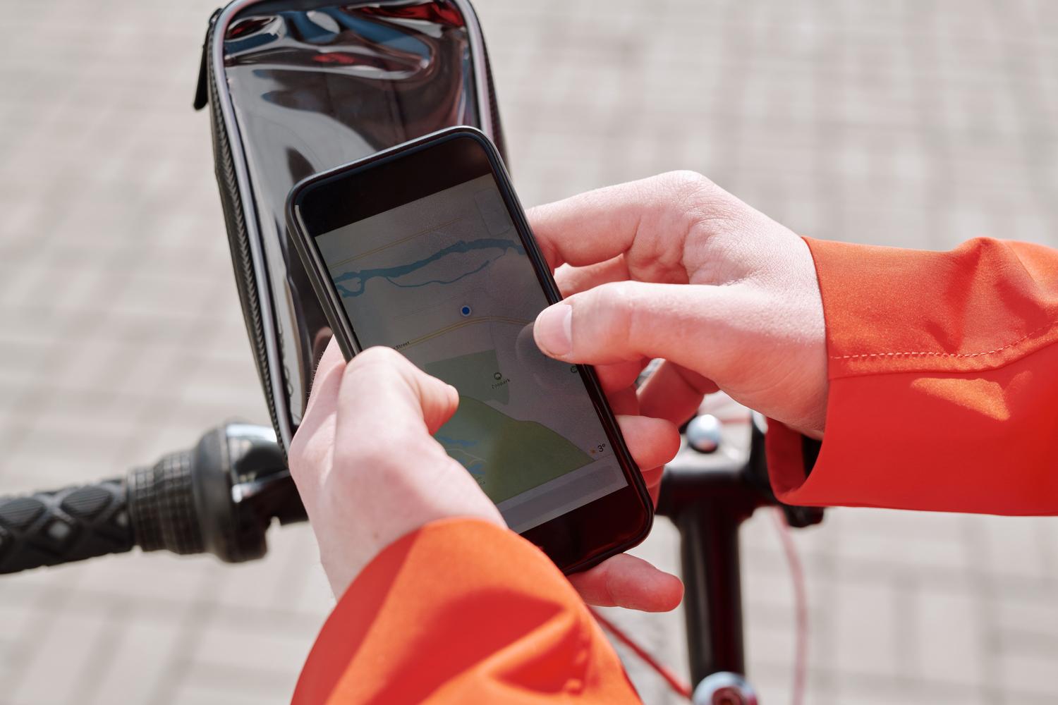Cyclist using the GPS on his smartphone mounted on the handlebars of his bicycle to follow a route.