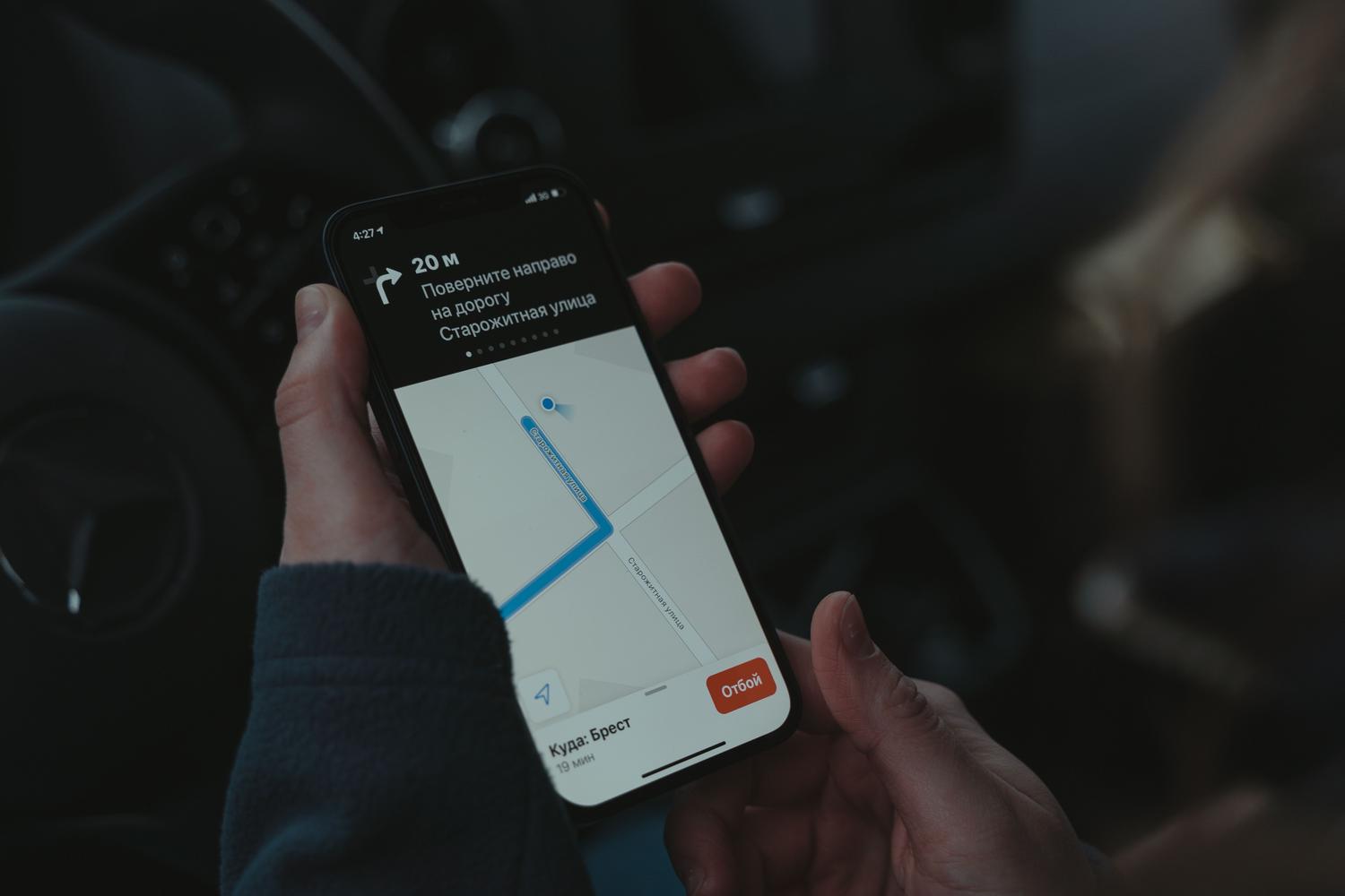 Smartphone with GPS navigation application installed on the dashboard of a car while driving.