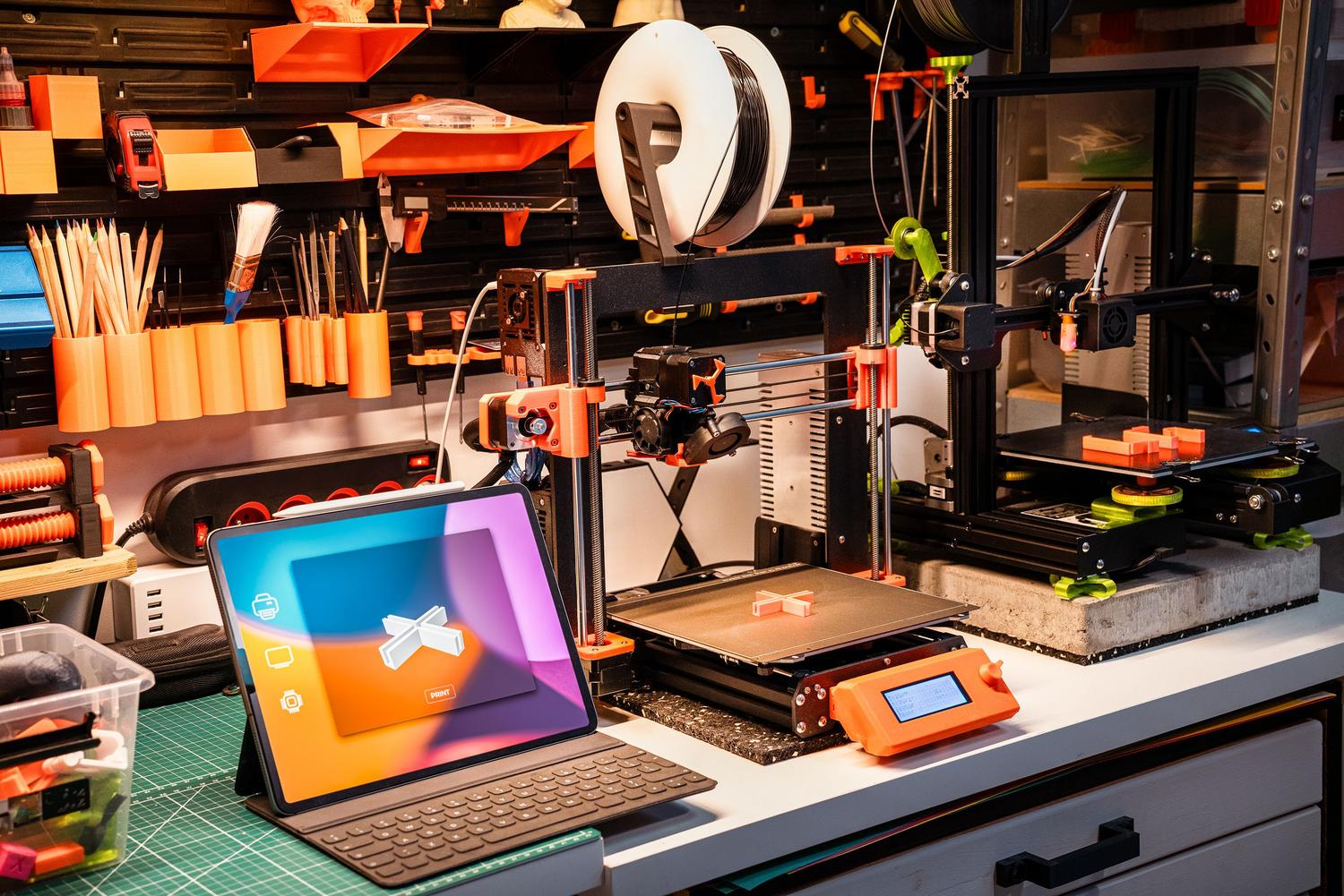 Taller de tecnología con impresoras 3D y tabletas, ilustrando la conexión entre el diseño digital y la simulación física