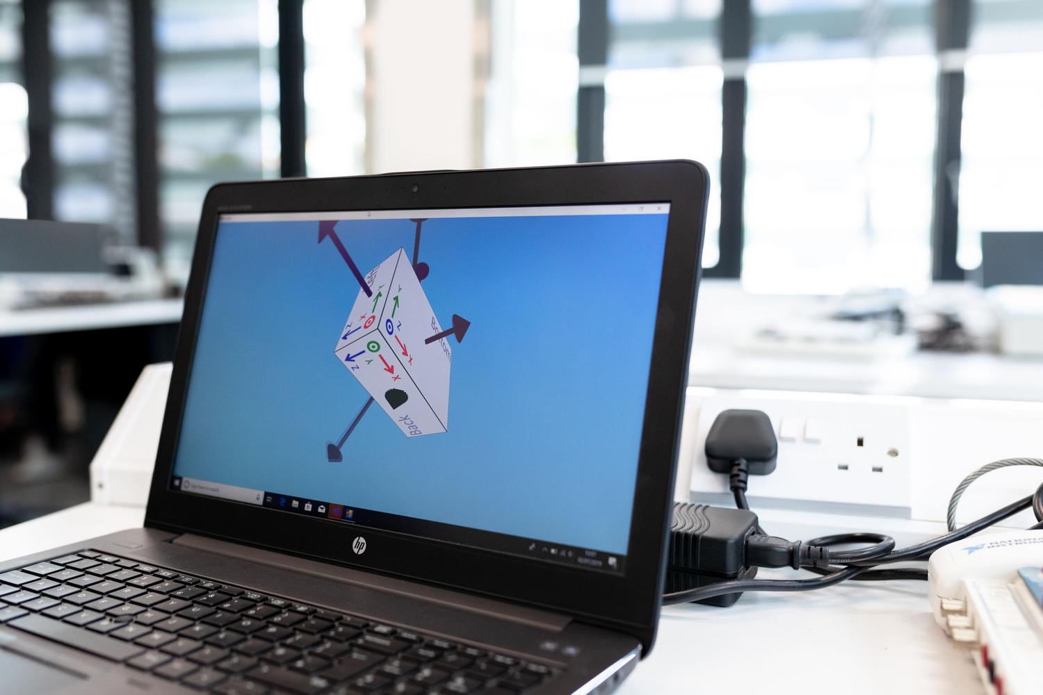 Laptop en una oficina mostrando un software de diseño 3D, ilustrando el uso de Blender para el modelado