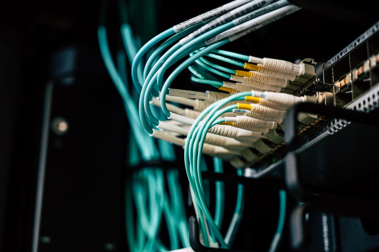 Detalle de cables de red en un rack de servidores, ilustrando la infraestructura de Azure DevOps y la nube.