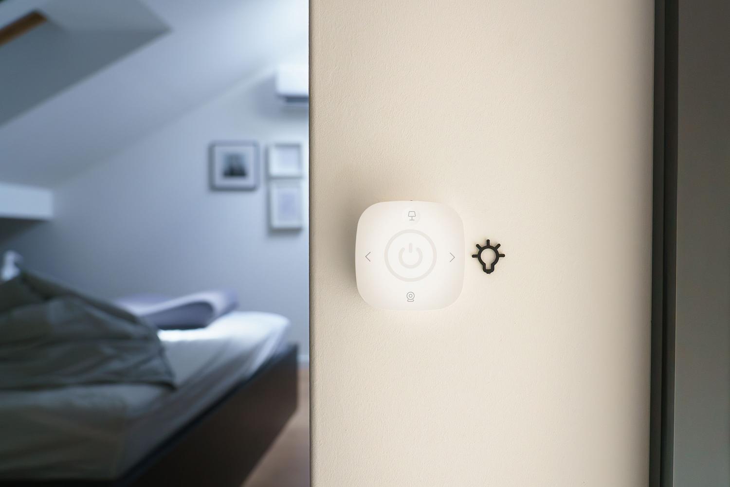 Interruptor inteligente instalado en la pared de un dormitorio moderno.