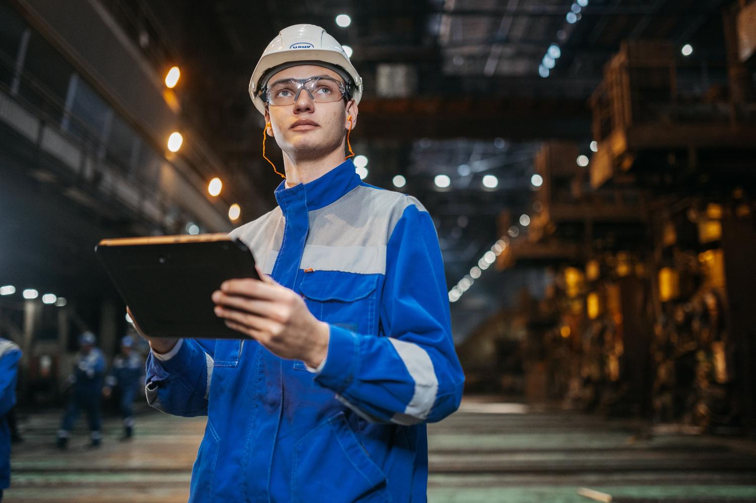Ingeniero industrial utilizando una tablet robusta en una planta de producción para monitorear datos en tiempo real.