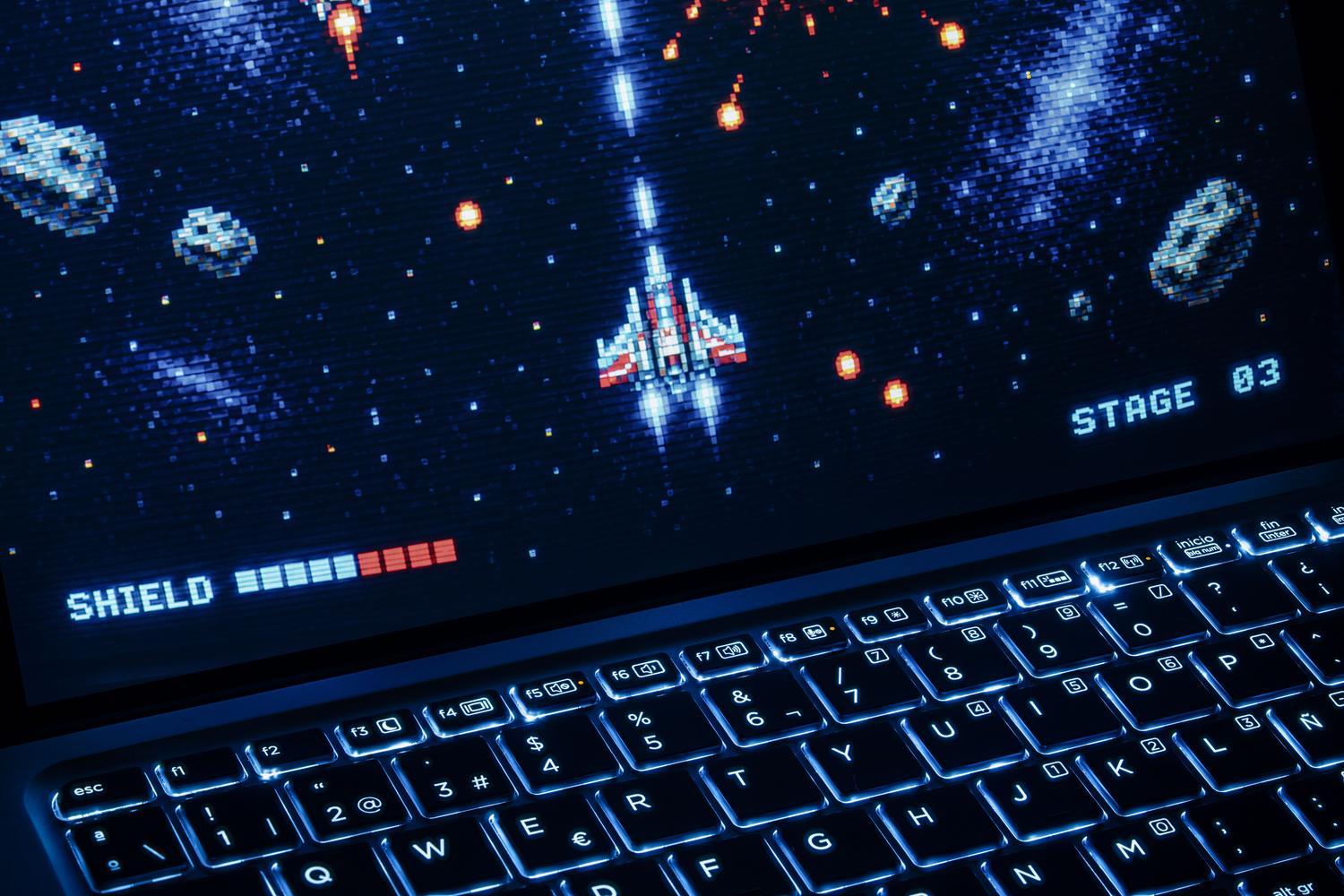 Portátil gaming con teclado retroiluminado y juego en pantalla, ilustrando la potencia de las GPUs en equipos portátiles.