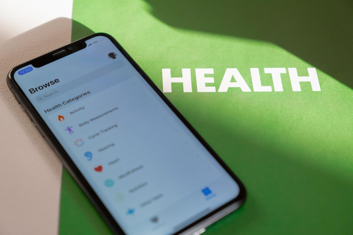 Smartphone mostrando la interfaz de la aplicación Apple Salud sobre un fondo profesional y minimalista.