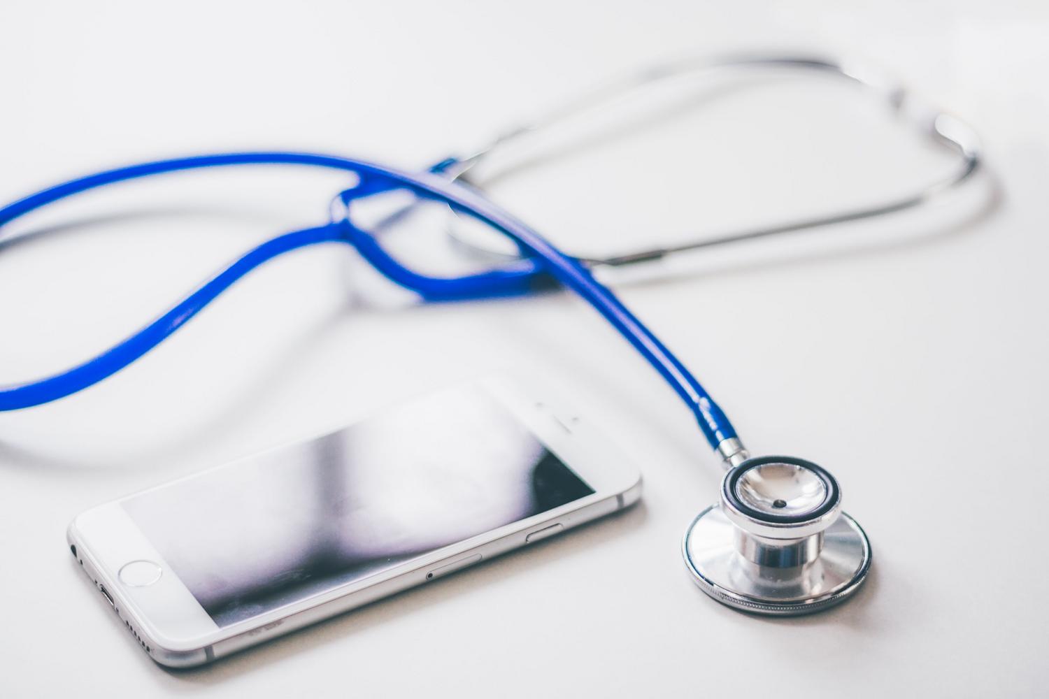 Composición de un smartphone y un estetoscopio que representa la unión entre la medicina tradicional y los datos de salud digitales.