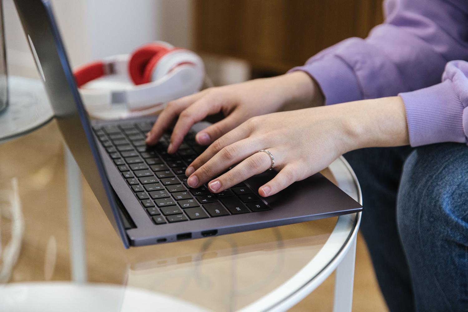 Primer plano de manos escribiendo en un teclado de ordenador portátil, ilustrando la configuración manual y los pasos técnicos de la migración.