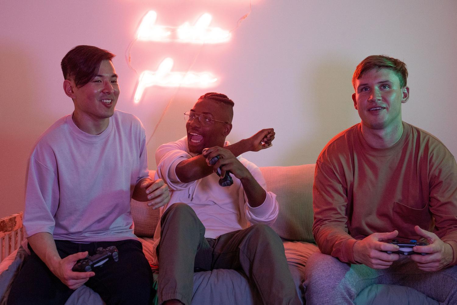 Grupo de amigos disfrutando juntos de una sesión de videojuegos en un ambiente con luces de neón, ilustrando la armonía en el juego cooperativo.