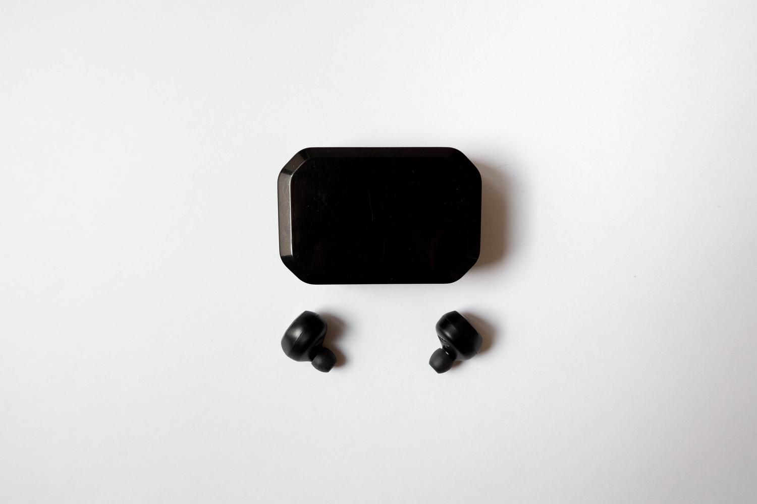 Auriculares inalámbricos tipo earbuds con su estuche de carga sobre un fondo blanco.