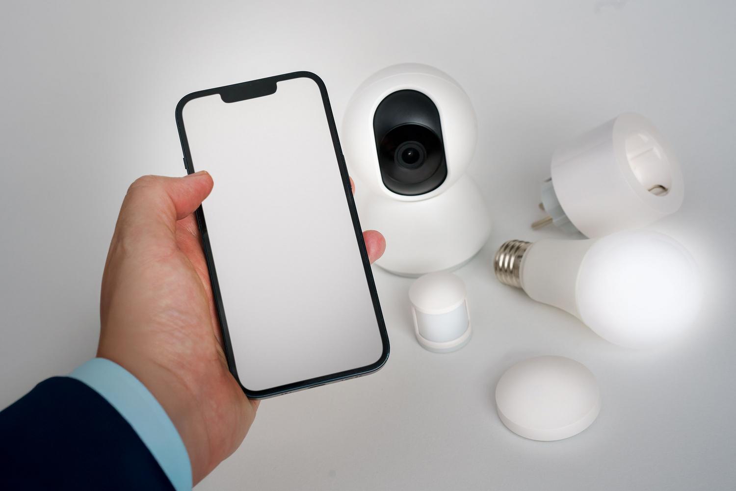 Persona utilizando un smartphone para gestionar dispositivos de domótica en un entorno limpio y moderno.