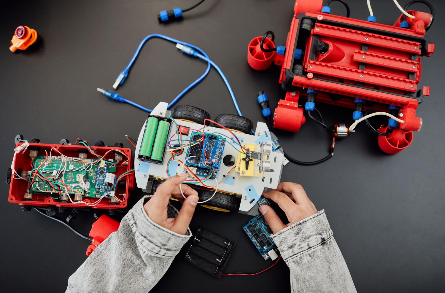 Jóvenes entusiastas de la robótica ensamblando un prototipo con placas de control y motores.