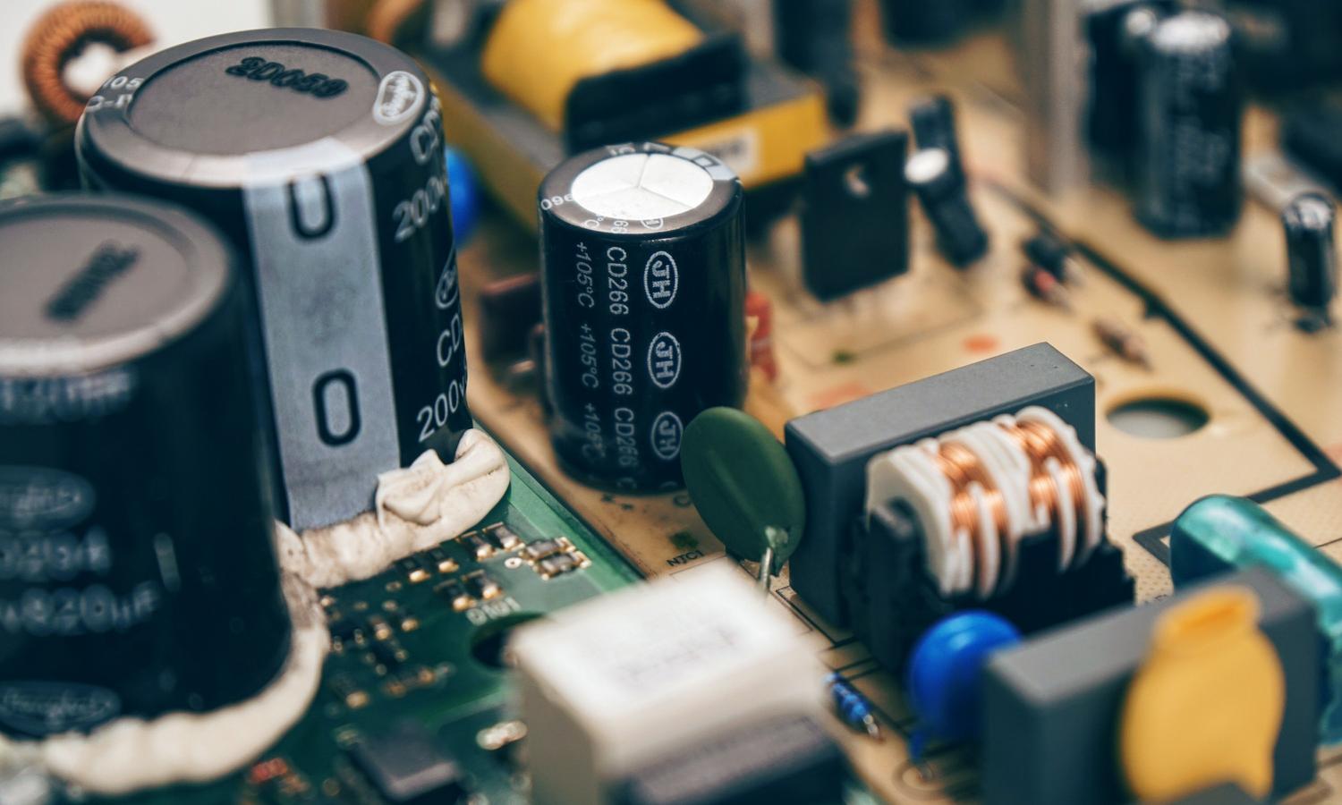 Primer plano de componentes electrónicos como resistencias y condensadores utilizados para crear divisores de tensión.
