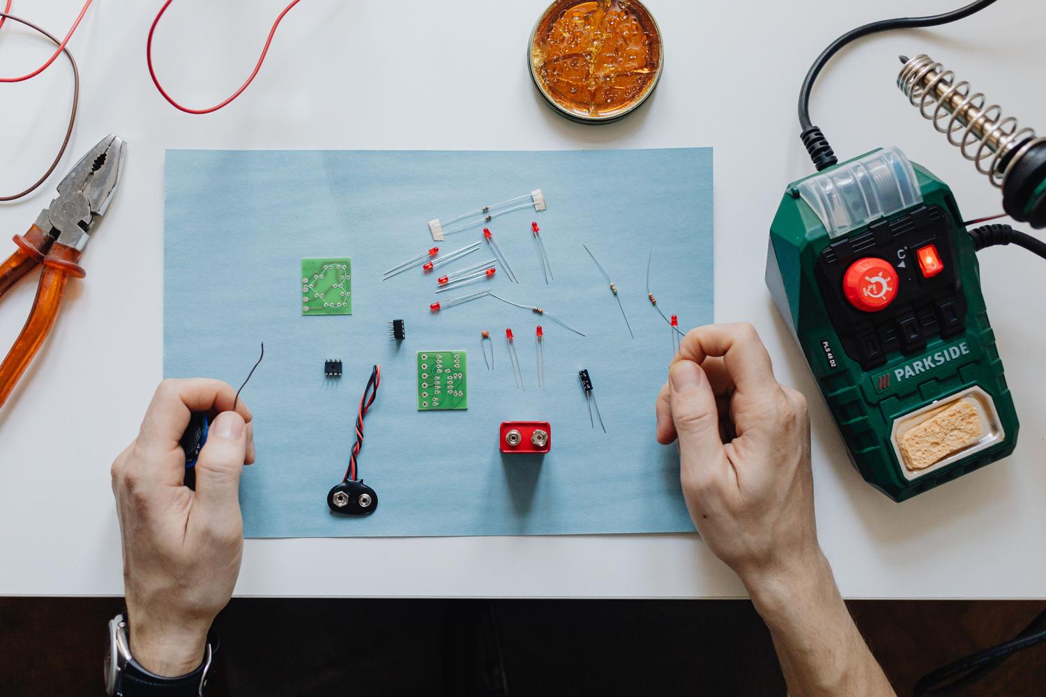 Espacio de trabajo de electrónica con herramientas y placas de circuito para montar el sistema de protección y acondicionamiento.